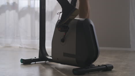 bicycle-training-at-home-man-is-spinning-pedals-closeup-of-feet-fitness-and-wellness-endurance-and-strength-for-health-cardiovascular-system